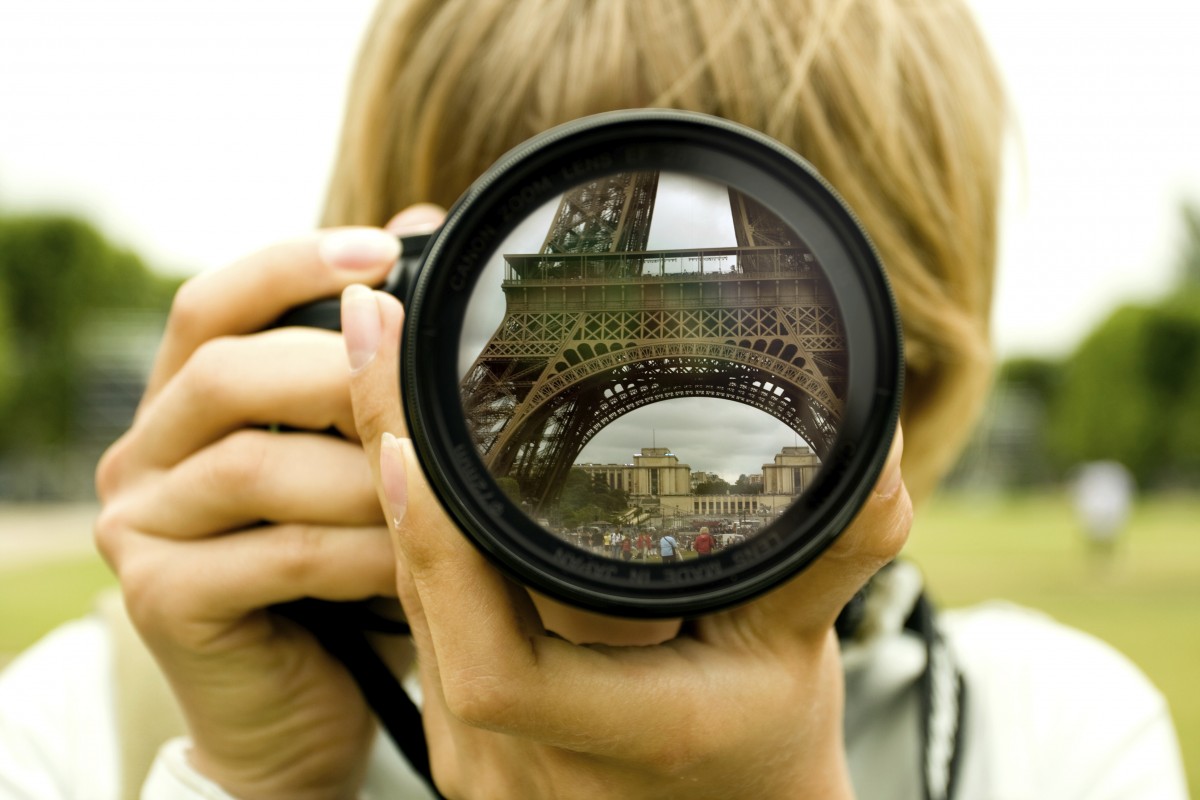 Woman taking photo with camera in Paris