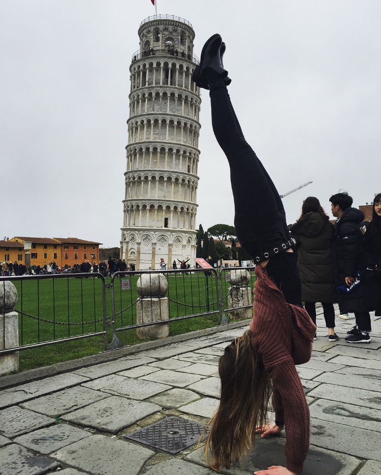 Global Leader Bella Martin does a handstand while on travel trip to Pisa