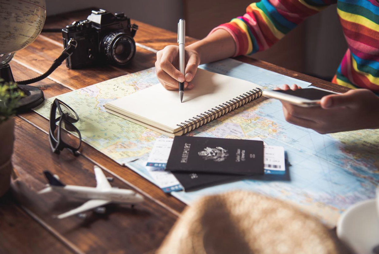 Internships Abroad: Benefits, Opportunities & Tips A person takes notes on top of a world map with passports and plane tickets nearby